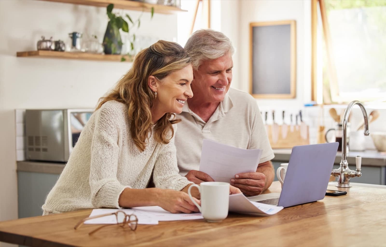 A retired couple reviewing their investment statements together at home