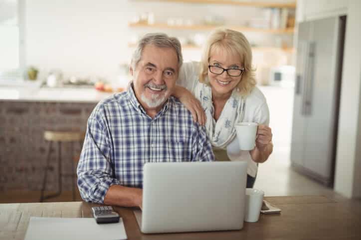 Older man and woman looking at a laptop, representing retirement planning by Peterson Wealth Advisors.