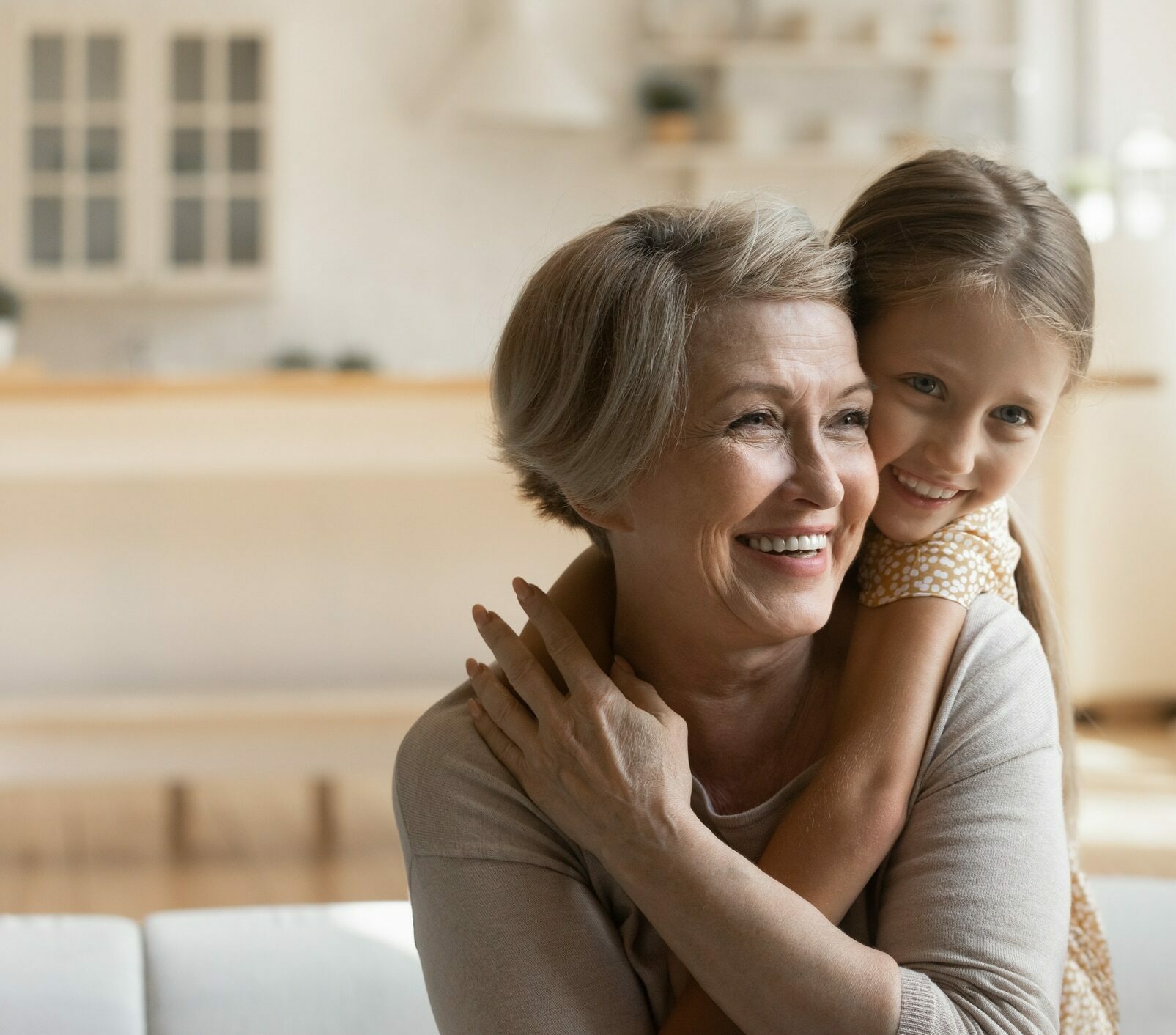 Head shot smiling mature grandmother piggy backing little granddaughter, representing Retirement Income Planning